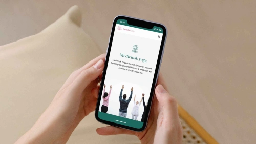 Bild på yogastudion Cawatayogas hemsida i mobilen som Balowie anlitades som webbdesigner för att göra.